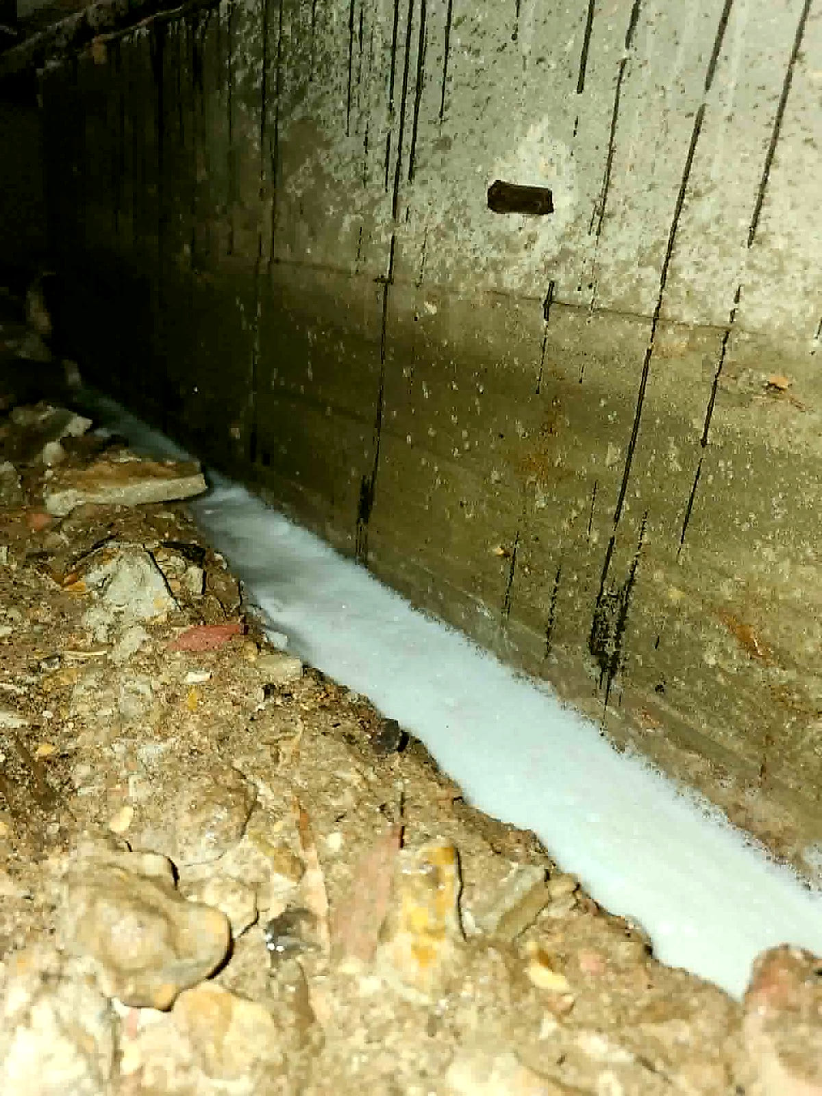 A trench along the foundation filled with foaming termiticide